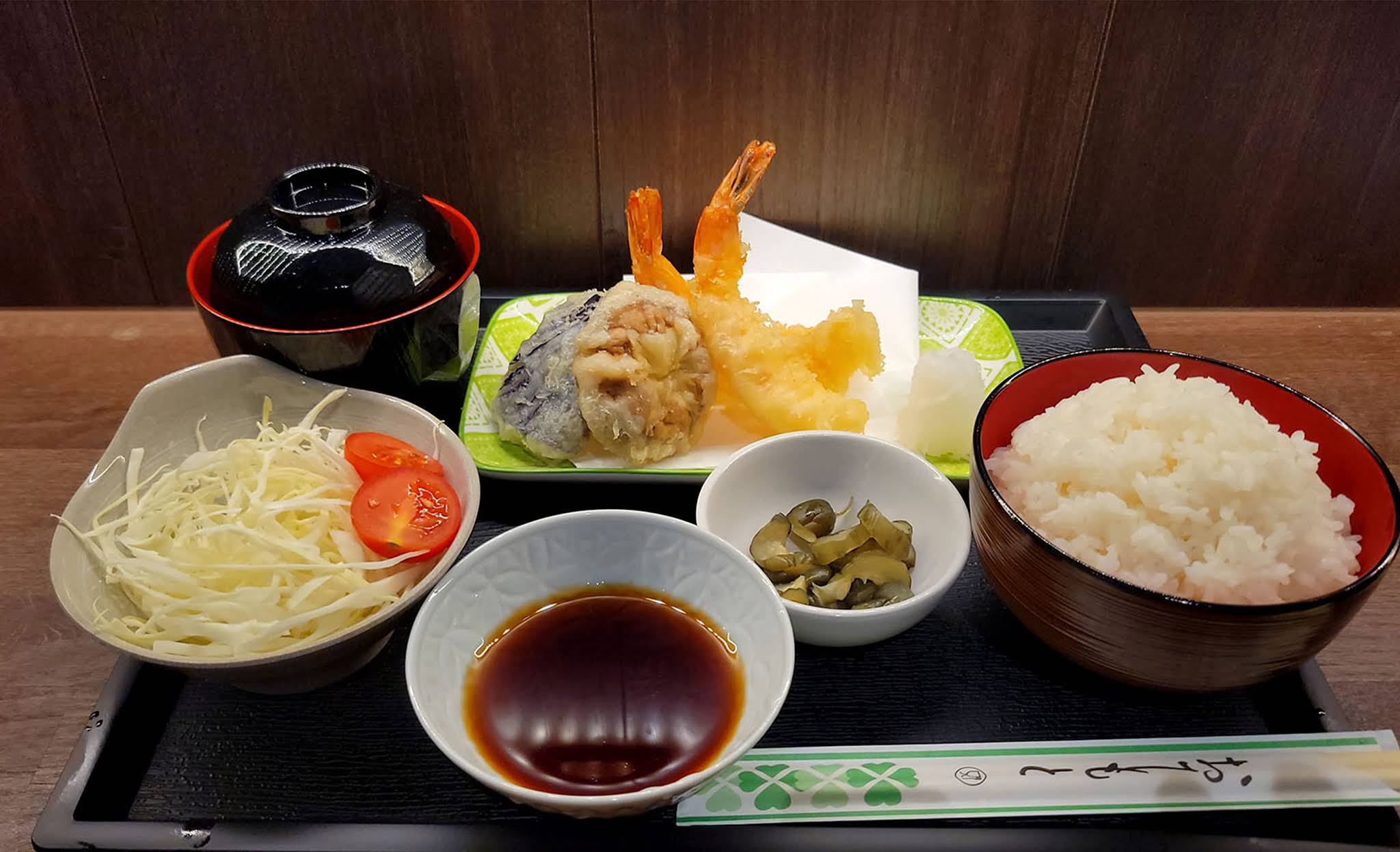 A Kome meal with battered prawns, rice, soup and vegetables on a black tray